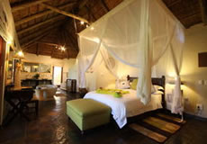 Double Bed, light and chair with door open to see bushveld
