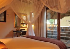 Double Bed, light and chair with door open to see bushveld