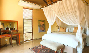 Four poster bed in bedroom of Elephant Plains Lodge