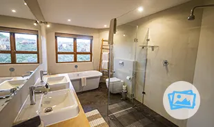 Bathroom with sinks on left and bath at the far wall