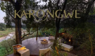 Deck and dining area lit up in the evening overlooking the river bed
