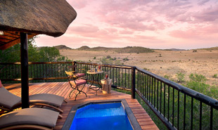 Pool deck and chairs with view over Pilanesberg from Tshukudu Bush Lodge