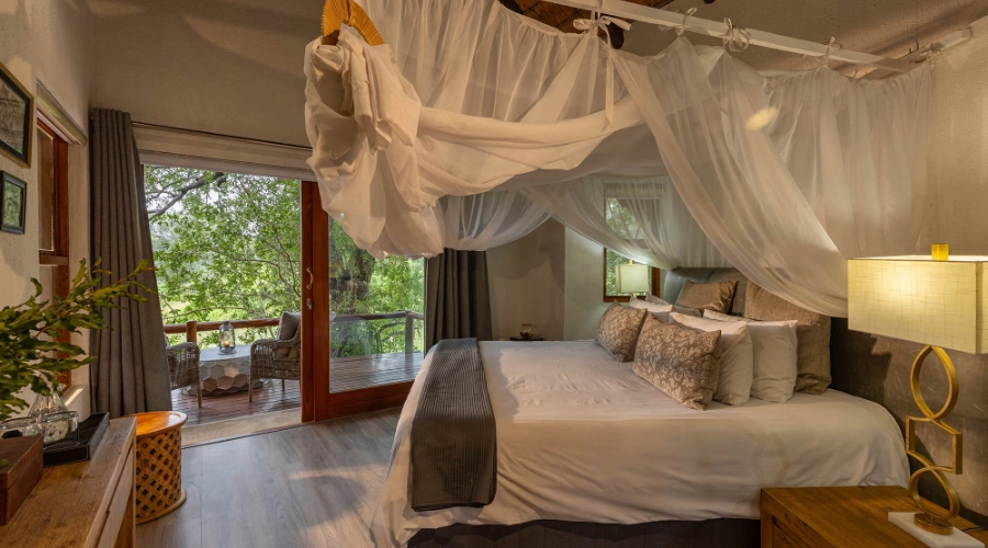 Interior of bedroom with bed and glass doors at the backl